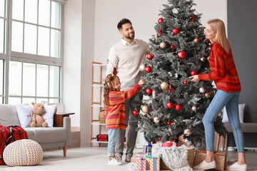 Young family decorating Christmas tree at home