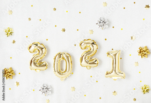 Happy New year 2021 celebration. Gold foil balloons numeral 2021 and gold star on silver background. Flat lay.
