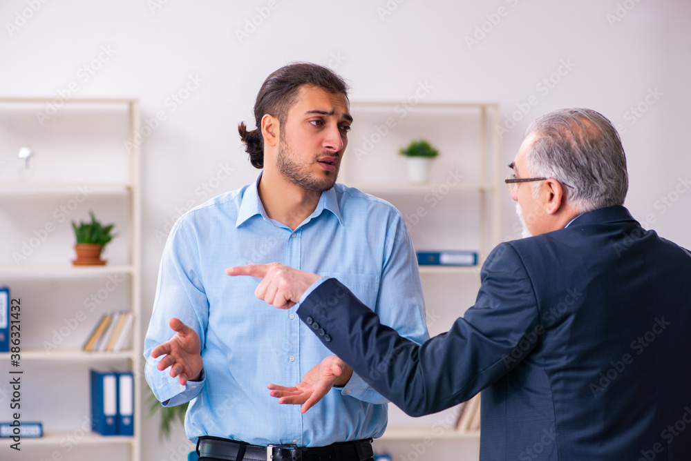 Obraz premium Old boss and his young assistant in the office