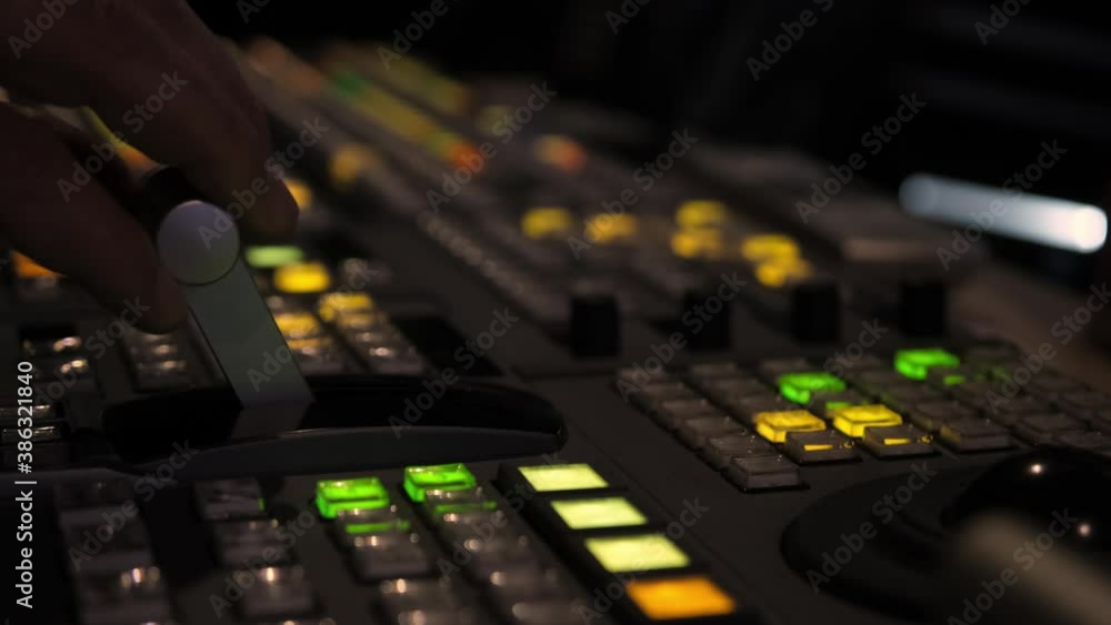 Television director is moving handle on a control panel during tv filming in studio Television director is moving handle on a control panel during tv filming in studio