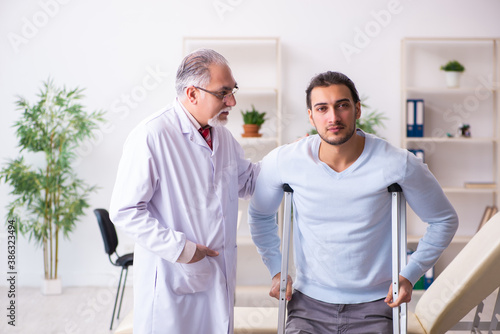 Young leg injured man visiting old doctor osteopath © Elnur