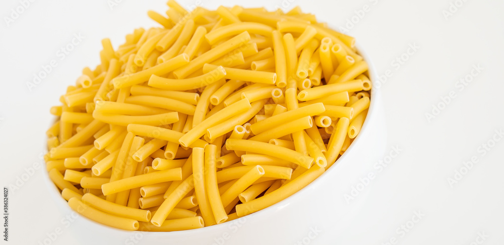 Raw dry uncooked Macaroni pasta spaghetti noodle on white bowl wooden background for basil tomato pesto sauce Homemade Italian food organic whole wheat vegan spaghetti for a healthy meal Raw dry uncooked Macaroni pasta spaghetti noodle on white bowl wooden background for basil tomato pesto sauce Homemade Italian food organic whole wheat vegan spaghetti for a healthy meal