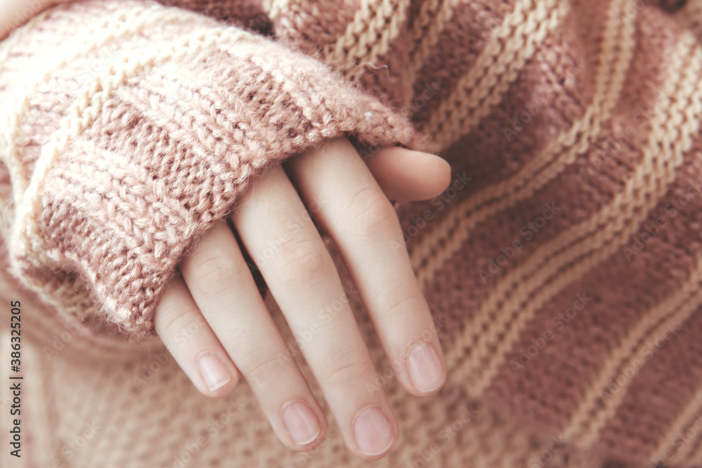 Woman in a beige soft warm knitted sweater folded her hands in the sunlight. Autumn soon Woman in a beige soft warm knitted sweater folded her hands in the sunlight. Autumn soon