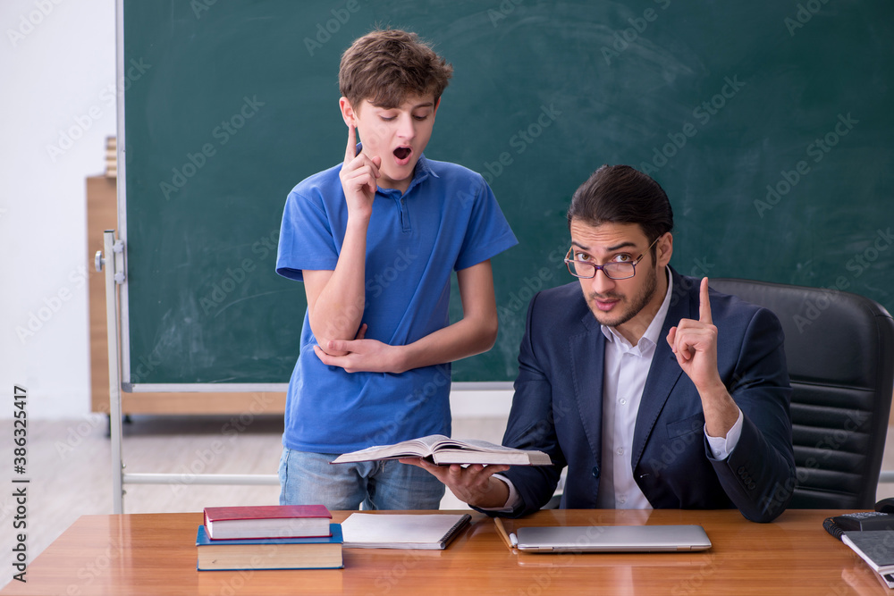 Young male teacher and schoolboy in the classroom Young male teacher and schoolboy in the classroom