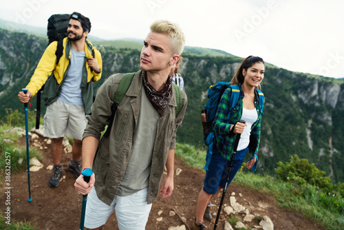 Group of happy friends with backpacks hiking together