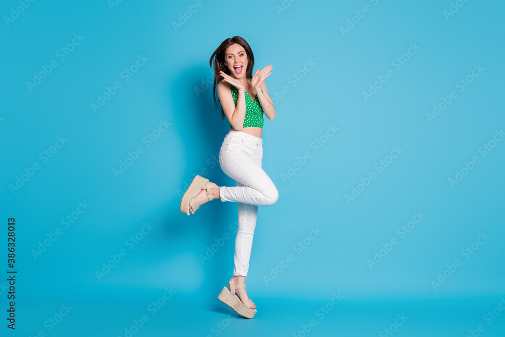 Full size photo of astonished positive cheerful girl jump impressed season discount wear good look clothes shoes isolated over blue color background Full size photo of astonished positive cheerful girl jump impressed season discount wear good look clothes shoes isolated over blue color background