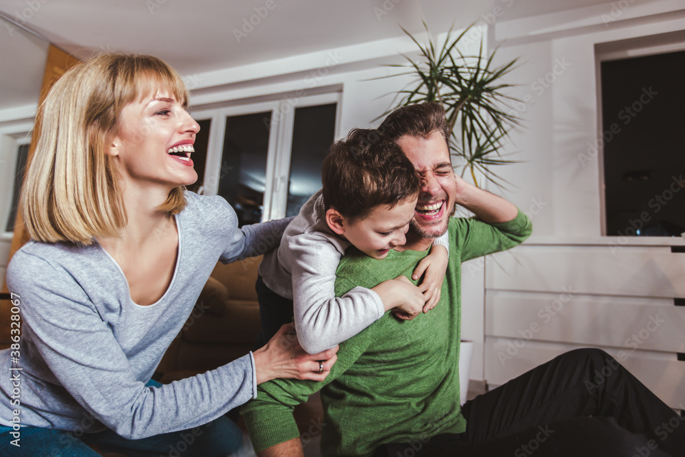 Family sitting on floor and playing together at home. Selective focus. Family sitting on floor and playing together at home. Selective focus.