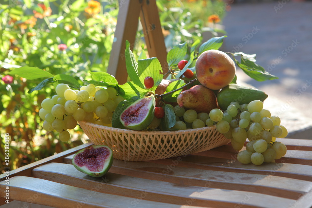 Grapes, figs, peaches and pears in a wicker basket Grapes, figs, peaches and pears in a wicker basket