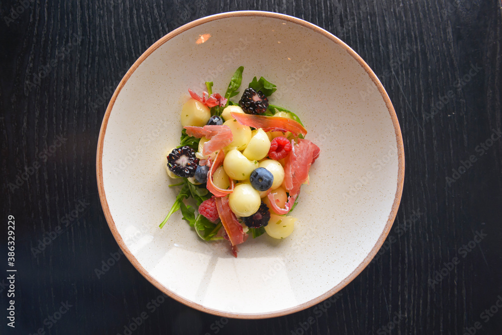 Salad of mixed summer berries. Seasonal summer salad with fruit and berries and Italian prosciutto meat. Salad of mixed summer berries. Seasonal summer salad with fruit and berries and Italian prosciutto meat.