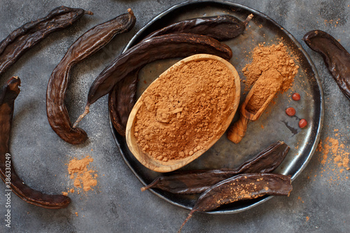 Dry carob pods and powder top view photo