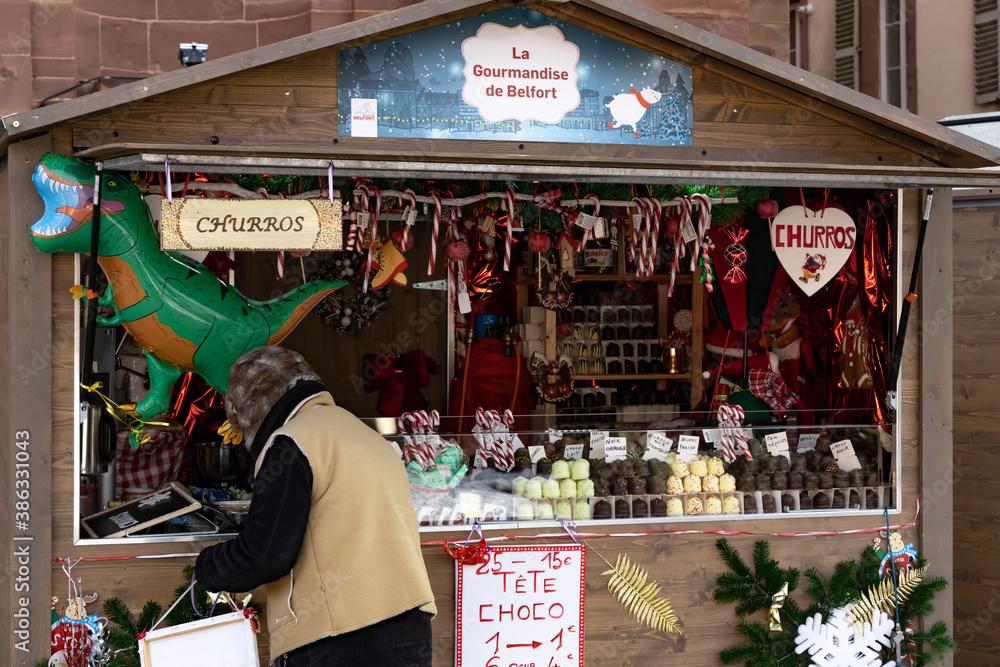 Naklejka premium Belfort, France - .December 14, 2019: Christmas market fair kiosk with handmade Christmas decorations and sweets.