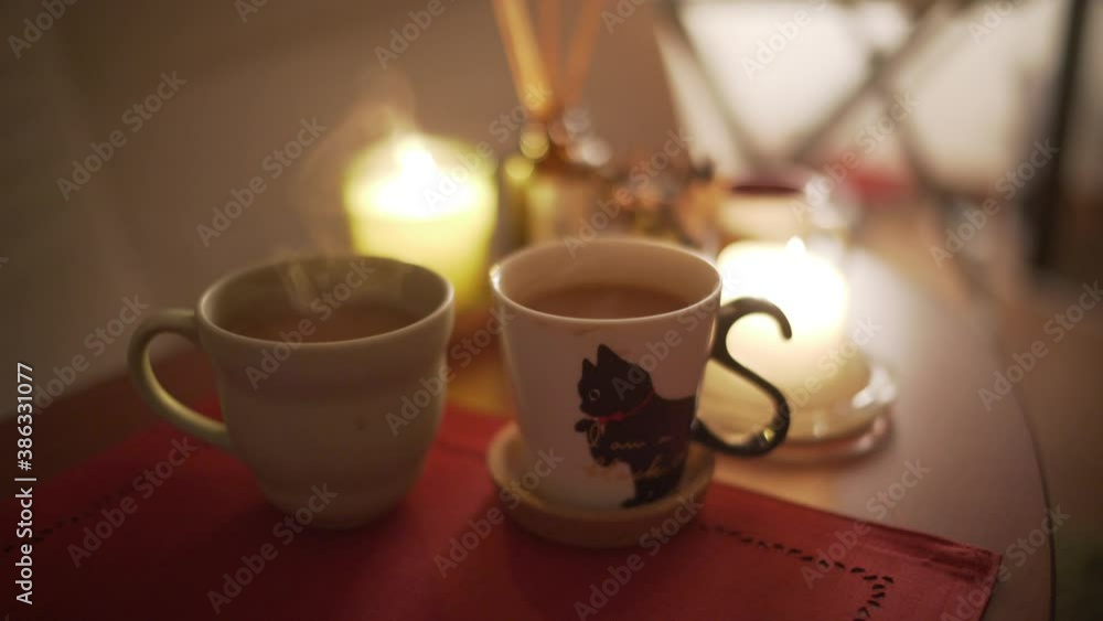 Two Cups Of Hot Beverage With Candlelights On The Table - close up Two Cups Of Hot Beverage With Candlelights On The Table - close up