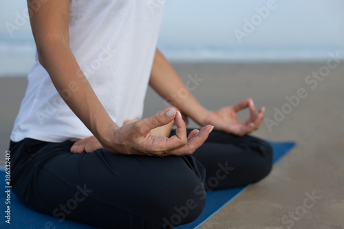 a girl meditates on the beach. hands fingers wise