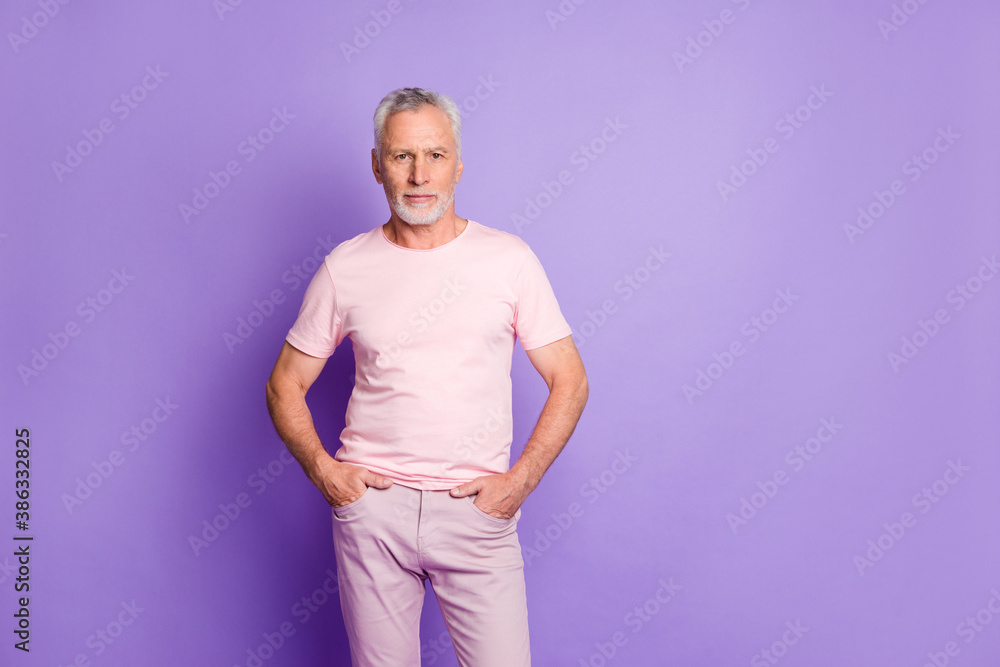 Obraz premium Photo of self-assured grandfather hands pockets look camera wear pink t-shirt pants isolated violet color background