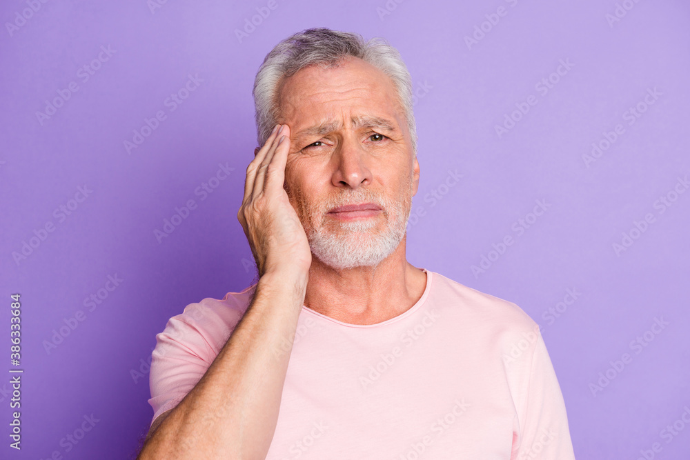 Photo of pensioner grandpa hand head tired look camera wear pink t-shirt isolated violet color background Photo of pensioner grandpa hand head tired look camera wear pink t-shirt isolated violet color background