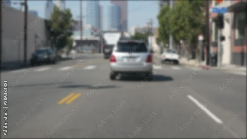 Driving on downtown streets of Los Angeles, California USA. Defocused view from car thru glass windshield on driveway. Blurred road with vehicles in Hollywood area, LA city aesthetic. Driving on downtown streets of Los Angeles, California USA. Defocused view from car thru glass windshield on driveway. Blurred road with vehicles in Hollywood area, LA city aesthetic.