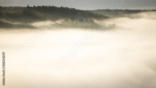 Fog and mist covering Blaubeuren with the castle Rusenschloss on the mountain