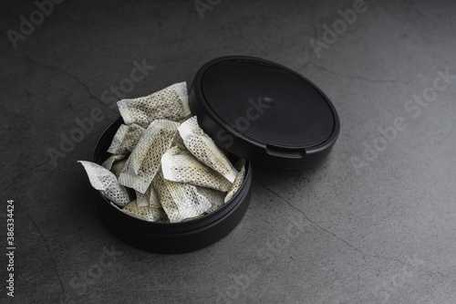 Fotografija Snus container on concrete. Swedish smokeless tobacco product.