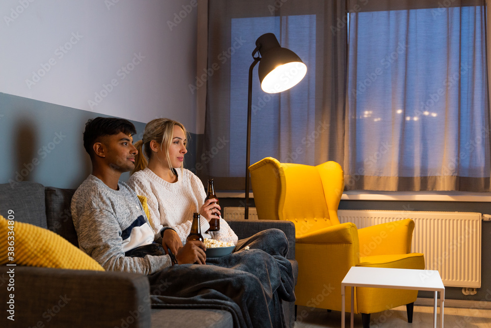 Couple watching TV during the evening in the living room.. Couple watching TV during the evening in the living room..