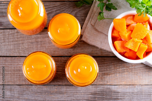 Baby food. Baby puree from fresh pumpkin in glass jars on a wooden table. Top view. The concept of baby food.