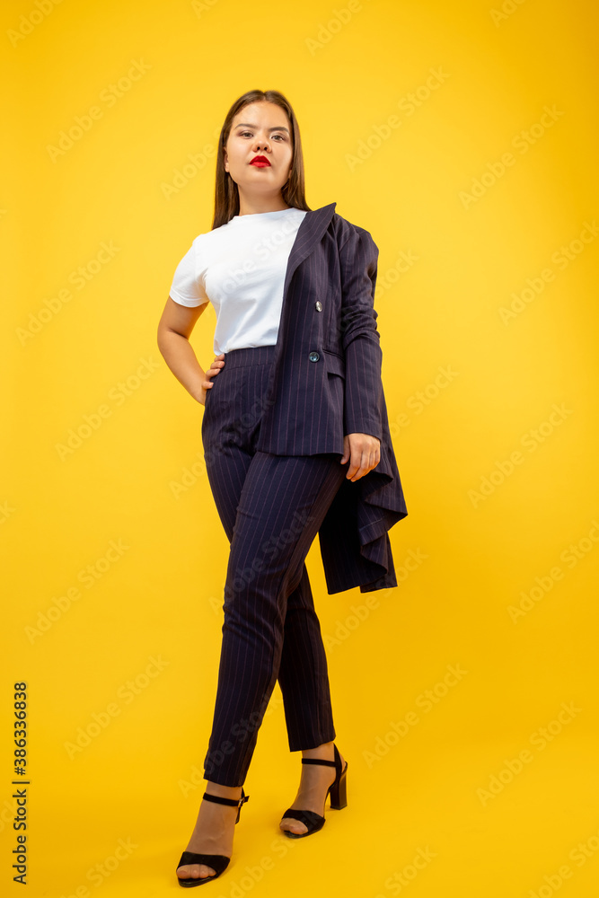 Successful woman. Business fashion. Smart casual look. Female empowerment. Confident ambitious lady in suit standing isolated on orange copy space background. Successful woman. Business fashion. Smart casual look. Female empowerment. Confident ambitious lady in suit standing isolated on orange copy space background.