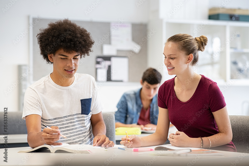 Teen students studying together at school Teen students studying together at school