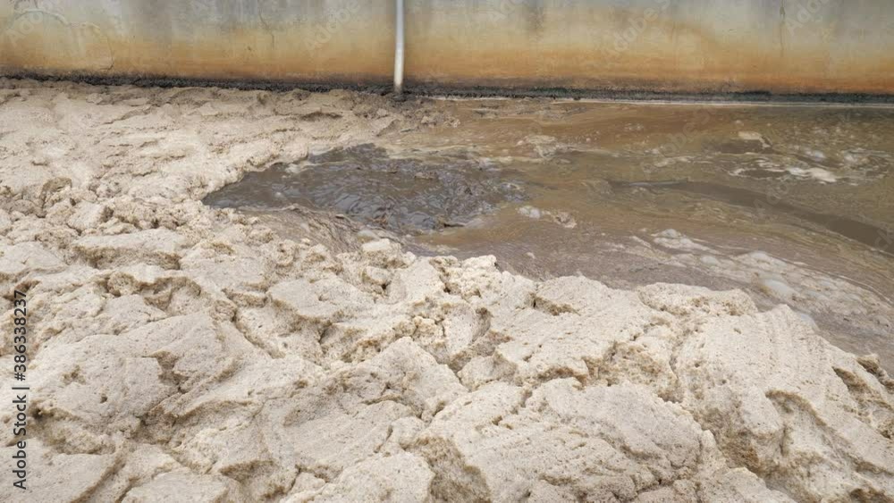 Residual methane and air bubles leave digestible biomass in a sedimentation tank. Thick brown foam. Residual methane and air bubles leave digestible biomass in a sedimentation tank. Thick brown foam.