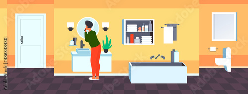 man looking to mirror brushing teeth with toothbrush health care dental hygiene concept modern bathroom interior rear view horizontal full length vector illustration