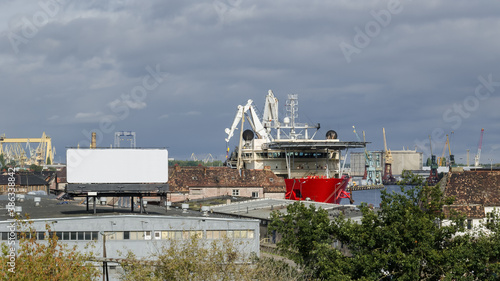 SHIP IN SEAPORT - Specialized watercraft moored at the wharf against the background of old industrial buildings
