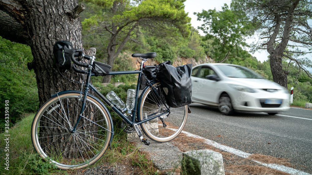 Touring bicycle standing near the road with back panniers