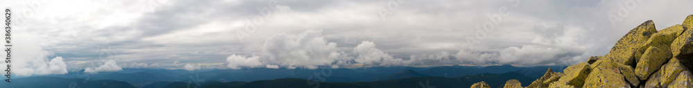 Panorama of mountain peaks. Panorama of rocky placers and storm clouds