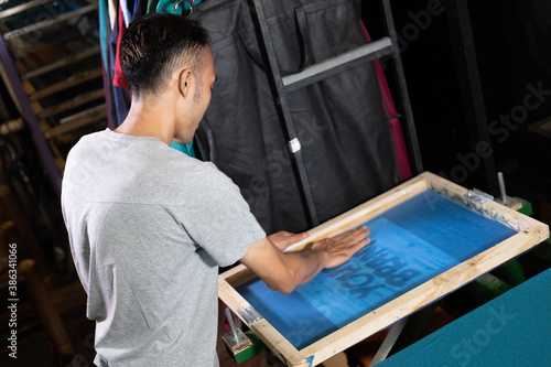 Fotografia man worker hold onto silk screen frames when preparing screen printing film