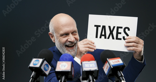 Politician holding a sign with taxes concept