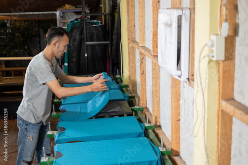 male workers prepare t-shirts placed on the board before screen printing © Odua Images