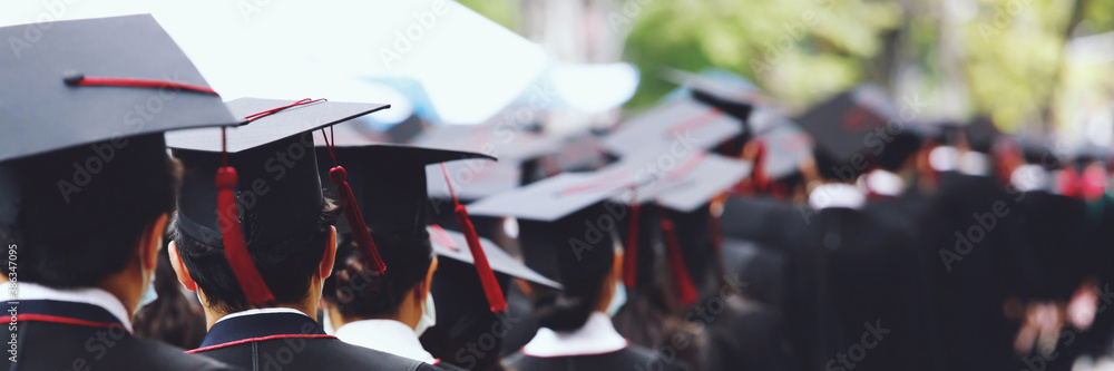 Group of Graduates during commencement stand in row. Concept education congratulation in University. Graduation Ceremony. copy space banner. - obrazy, fototapety, plakaty 