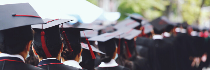 Group of Graduates during commencement stand in row. Concept education congratulation in University. Graduation Ceremony. copy space banner.