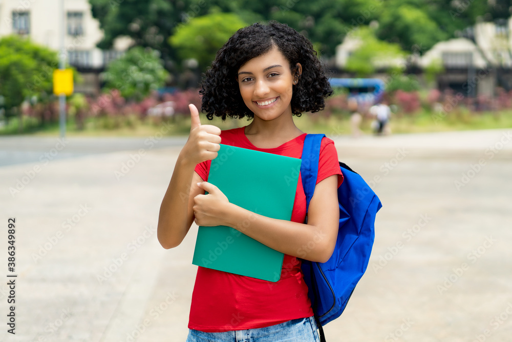 Cheering hispanic female college student with backpack Cheering hispanic female college student with backpack