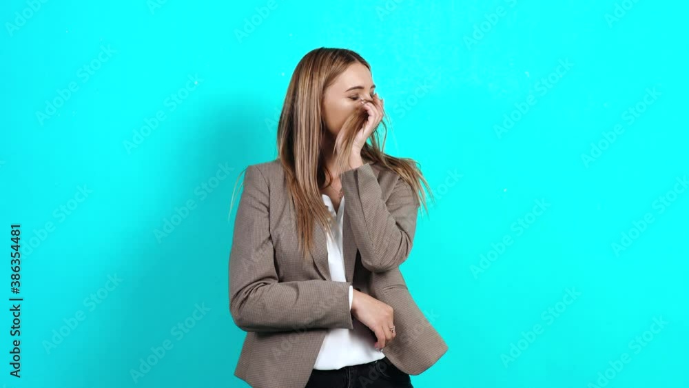 Beautiful self-confident young woman in a business suit, playing with brown hair, showing her new hairstyle. Studio image indoors, isolated on blue background Beautiful self-confident young woman in a business suit, playing with brown hair, showing her new hairstyle. Studio image indoors, isolated on blue background