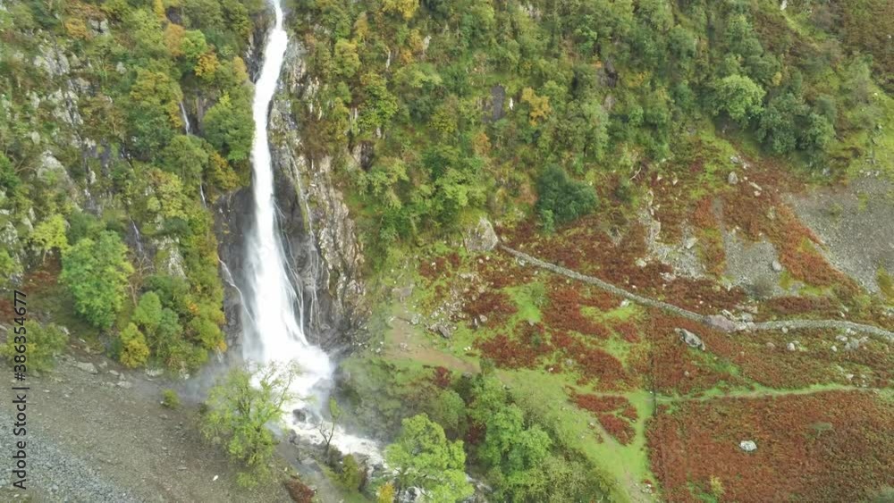 Idyllic Snowdonia mountain range Aber falls waterfalls national park aerial view birds eye pull back