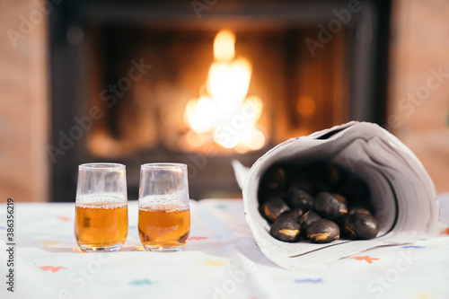 Toasted chestnuts and two glasses with wine or 