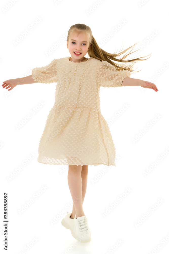 A cheerful little girl is dancing.The concept of a school of dance. A cheerful little girl is dancing.The concept of a school of dance.