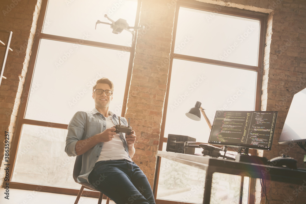 Portrait of his he nice attractive cheerful guy geek software developer expert controlling drone spending time at modern loft brick open space industrial home office work place station indoors