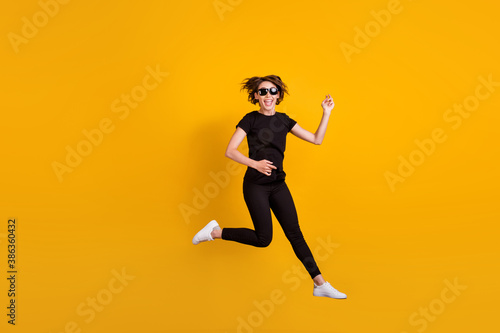 Full length body size view of attractive ecstatic carefree cheerful girl jumping having fun fooling isolated bright yellow color background