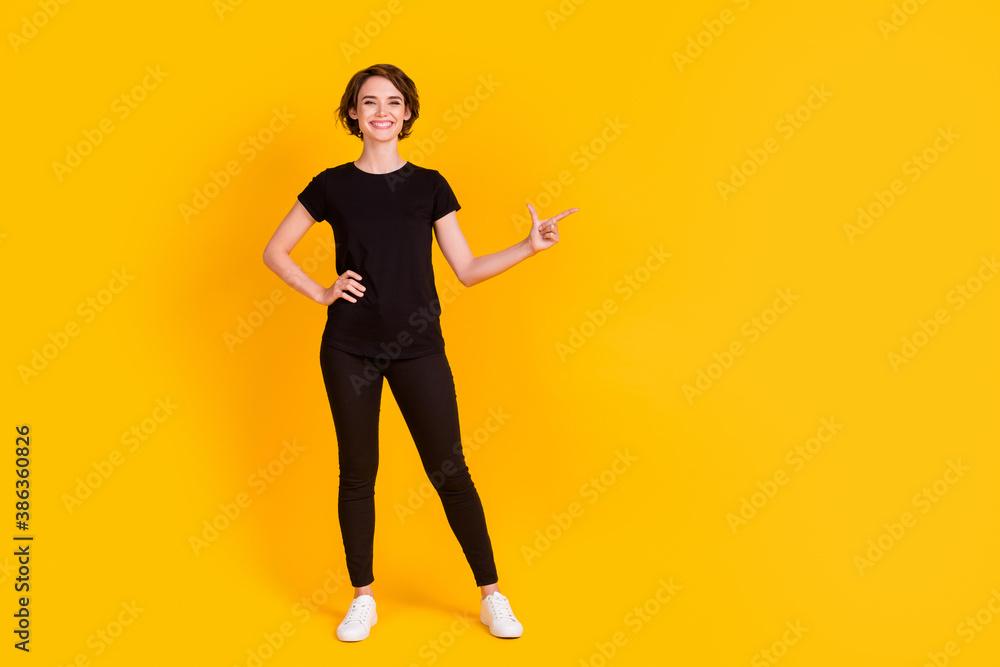 Full length body size view of attractive glad cheerful girl showing aside copy space solution isolated bright yellow color background Full length body size view of attractive glad cheerful girl showing aside copy space solution isolated bright yellow color background