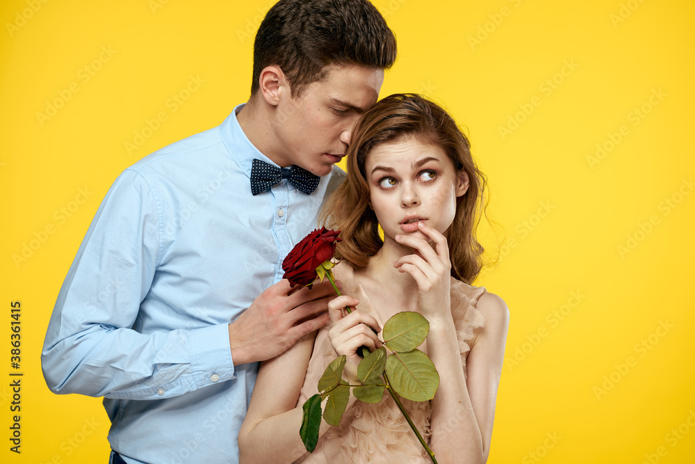Enamored man and woman with red rose on yellow background cropped view close-up romance Enamored man and woman with red rose on yellow background cropped view close-up romance