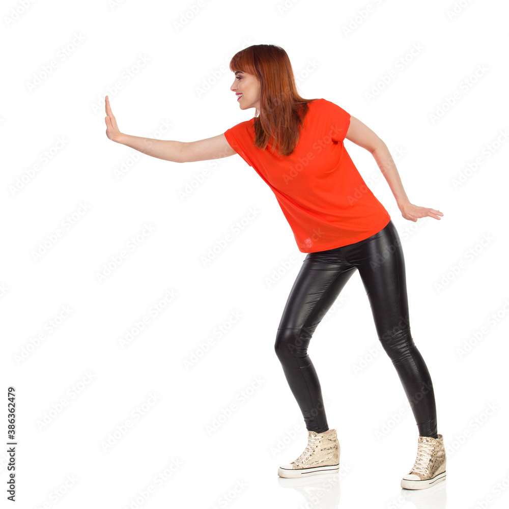 Smiling Young Woman Is Pushing Something With One Hand Smiling Young Woman Is Pushing Something With One Hand