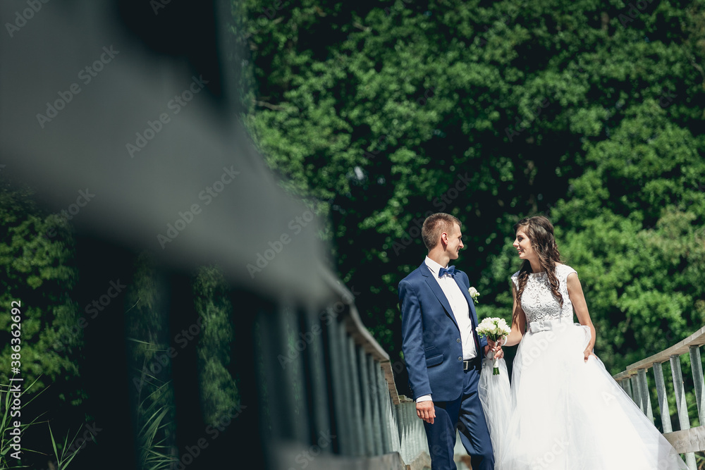 Fototapeta premium bride and groom walking in park