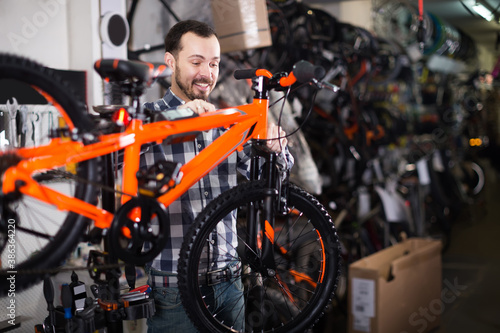 Young man assembles sports bike using screwdrivers and wrenches