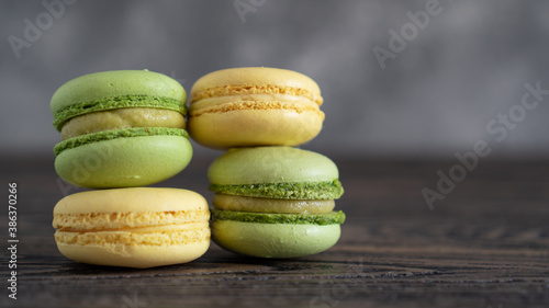 Fototapeta Naklejka Na Ścianę i Meble -  Yellow and green macaroons with pistachio and mango cream. Delicate cream filling in colored cakes