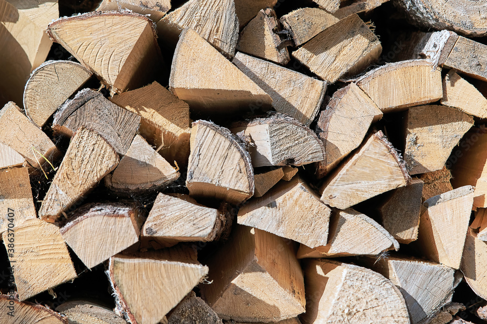 Chopped firewood stacked in a woodpile, view from the end of the masonry Chopped firewood stacked in a woodpile, view from the end of the masonry